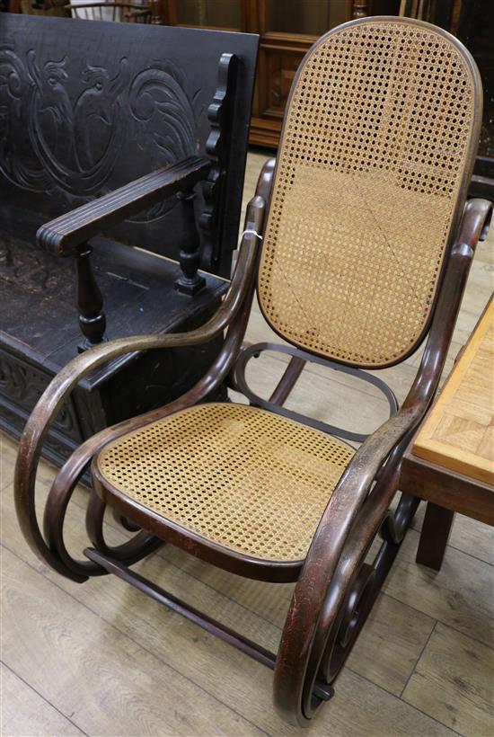 A stained beech bentwood rocking chai, with caned seat and back